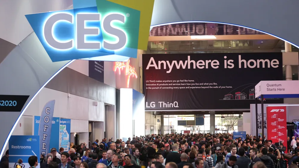 ALT Text:A possible short ALT text for this image could be:  Large crowd gathered at CES under an archway with the CES logo