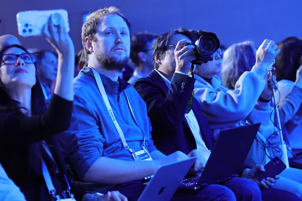 ALT Text: people watching a keynote presentation 